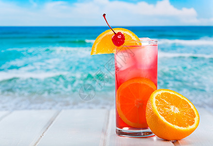 海滩上橙色切片的水果鸡尾酒图片