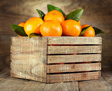 木制盒子里叶子的新鲜橘子图片