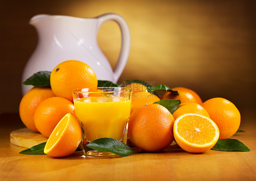 杯橙汁新鲜水果放木桌上图片