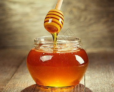 蜂蜜倒进木制的碗里图片
