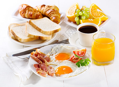 早餐包括煎鸡蛋牛角包果汁咖啡水果图片