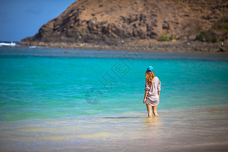 轻的女人海滩上散步图片