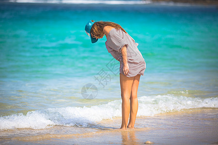 轻的女人海滩上散步图片