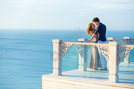 夫妇阳台上摆姿势,背景海洋图片