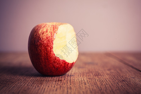 张木制桌子上吃了半的苹果图片