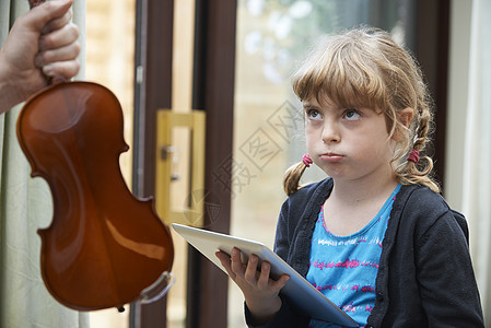 轻女孩宁愿数字平板上演奏,也愿练小提琴图片