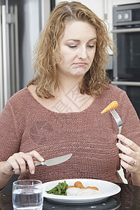 节食的女人厌倦了吃健康的饭菜图片