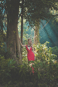 热带森林里穿着红色连衣裙的轻漂亮女士高清图片