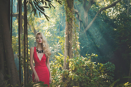热带森林里穿着红色连衣裙的轻漂亮女士图片