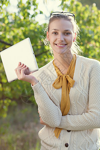 快乐的轻女人户外着iPad图片