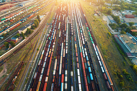 彩色货运列车的顶部视图火车站上五颜六色的货运列车的飞行无人机上俯瞰铁路上货物的货车重工业工业场景图片