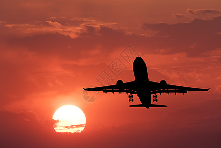 着陆飞机的轮廓带太阳的红色天空乘飞机的风景日落时与云天空中飞行旅行背景客机商业飞机生意图片