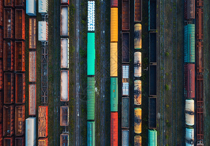 彩色货运列车的顶部视图火车站上五颜六色的货运列车的飞行无人机上俯瞰铁路上货物的货车重工业工业场景图片