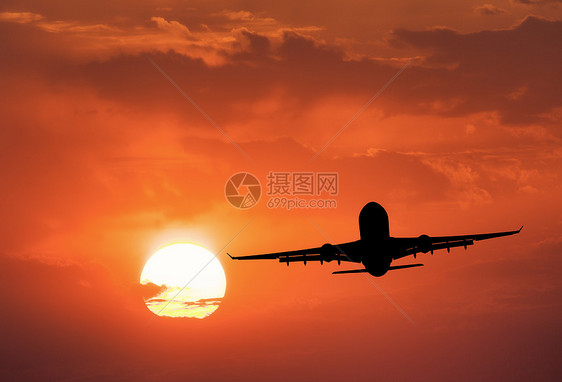 飞机的轮廓带太阳的红色天空乘飞机的风景日落时与云天空中飞行旅行背景客机商业飞机生意图片