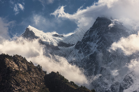庄严的场景与山脉与雪峰云尼泊尔五颜六色的景观,美丽的高岩石戏剧的多云天空日落自然背景仙女的场景神奇的山图片