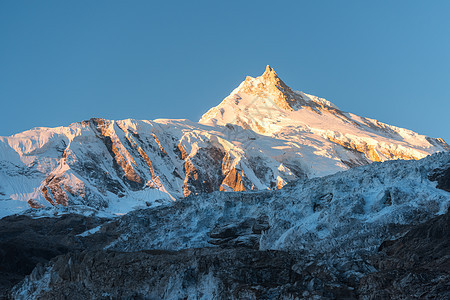 美丽的风景白雪覆盖的山五颜六色的日出尼泊尔风景与雪峰喜马拉雅山脉,冰川蓝天早上惊人的马纳斯鲁喜马拉雅山自图片