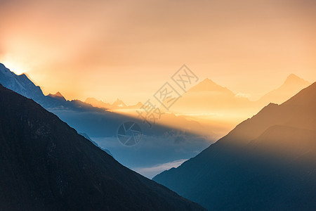 尼泊尔彩色日出时,群山低云的轮廓的雄伟景色喜马拉雅山脉的雪峰景观,美丽的天空阳光神奇的喜马拉雅山自然图片