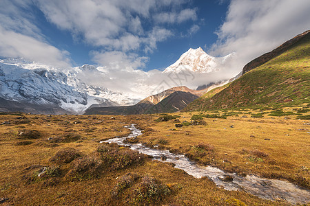 美丽的风景高山,积雪覆盖的山峰,小河,黄草多云的天空五颜六色的日出山谷尼泊尔喜马拉雅山脉的惊人景象自然图片