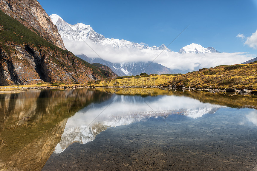 雄伟的山脉,高高的岩石,积雪覆盖的山峰,山湖,美丽的倒影水中,蓝天与云彩日落尼泊尔惊人的宁静景观与山脉喜马拉雅山图片