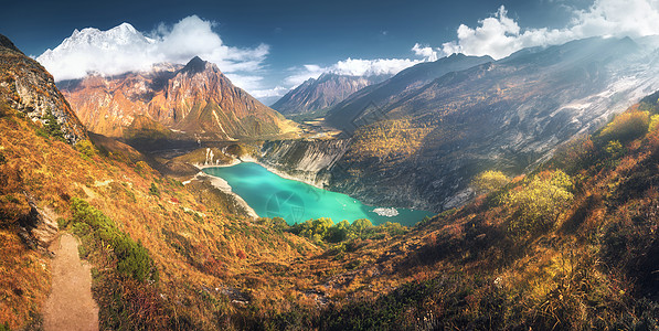 风景优美的喜马拉雅山,惊人的山湖与绿松石水,山丘,黄草,树木蓝天与云日落尼泊尔山谷全景景观背景图片