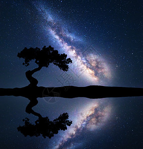 银河,河边的山上棵弯曲的树,天空水中反射五颜六色的夜晚景观与银河,星空湖泊夏天太空背景天体摄影图片