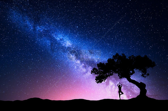 银河与老树个站立的女人练瑜伽的轮廓美丽的风景与冥想的女孩树下,星空与粉红色的银河神奇的星系宇宙图片