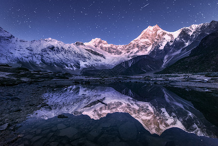 令人惊叹的夜景与喜马拉雅山脉山湖繁星的夜晚尼泊尔景观与高岩石与雪峰天空与星星反射水中美丽的玛纳斯鲁,喜马拉雅山背景图片