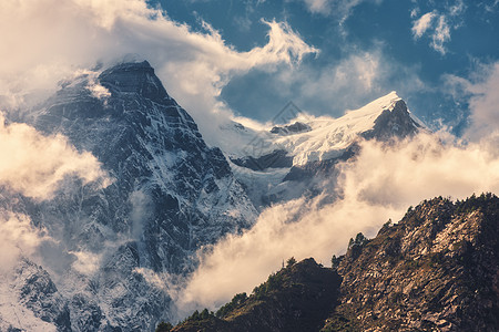 尼泊尔阳光明媚的傍晚,高山上雪峰五颜六色的景观,美丽的岩石戏剧的多云天空日落自然背景仙女的场景神奇的山脉图片