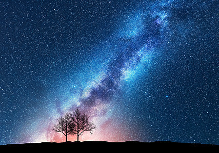 与银河抗星空的树木太空背景夜景观,山上只树木五颜六色明亮的银河神奇的星系自然与宇宙的美丽景象概图片