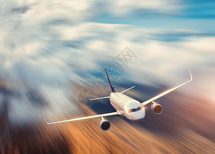 现代飞机运动模糊效应,日落时飞越低云客机,模糊的云彩,森林,黄昏的阳光客机商务旅行商业飞机图片