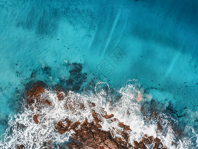 海浪岩石透明海洋的鸟瞰图夏季海景与海洋,沙滩,美丽的波浪,悬崖,蓝色的水日落无人机的顶部视图多岩石的海岸线图片