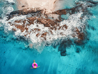 马尔代夫透明的绿松石海中,轻女子粉红色的游泳圈上游泳的鸟瞰图夏天的海景与女孩,海滩,美丽的波浪,岩石,蓝色的水日落图片