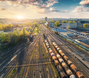 火车站彩色货运列车的鸟瞰图铁路上货物的货车货运火车重工业工业场景与火车,城市建筑蓝天日落的风景图片