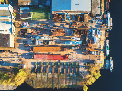 干船坞进行修理的船舶船只的鸟瞰图铁锈船的顶部视图干坞进行翻新日落时旧游艇建筑物树木足球场的工业场景干图片