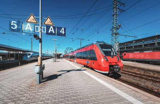 日落时火车站上的高速红色列车纽伦堡,德国铁路站台上的现代城际列车工业铁路上的通勤火车客运古董火车站上图片