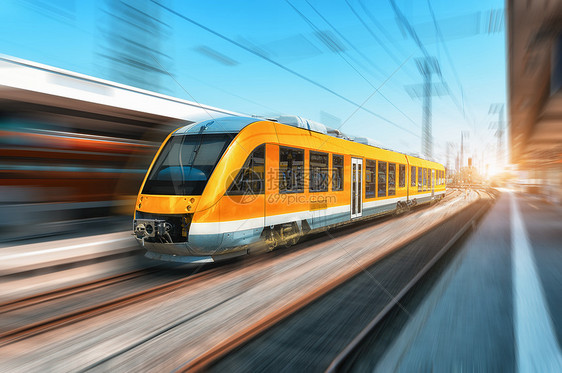 明亮的天,高速橙色列车火车站上运动现代城际列车铁路站台上运动模糊效应工业铁路上的客运通勤列车旅行高图片