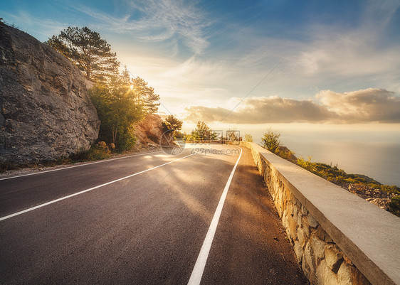 欧洲日落时的山路风景与岩石,晴朗的天空与云美丽的沥青路晚上的夏天丰富多彩的旅行背景山区的高速公路运输欧洲图片