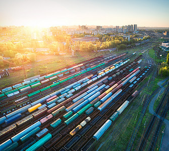 多色货运列车的鸟瞰火车站上的货车铁路上货物的货车重工业工业景观与火车,铁路平台日落顶部视图存储铁路图片