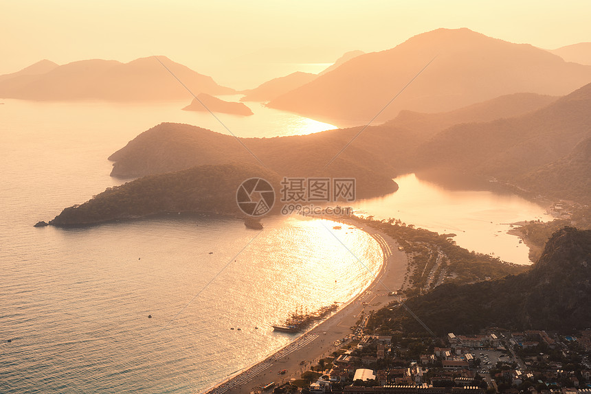 日落时美丽的海景夏季海洋山脉岛屿城市金色阳光橙色天空的景观土耳其奥卢登尼斯的山峰上看令人惊叹的景色旅图片