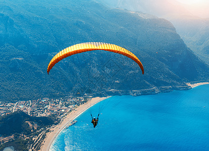 滑翔天空中滑翔伞串联飞行海上与蓝色的水,海滩山脉日出鸟瞰滑翔伞蓝色泻湖奥卢德尼兹,土耳其极限运动景观图片