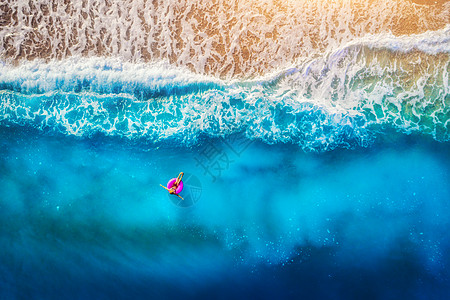 Oludeniz透明的海洋中,女人粉红色的游泳圈上游泳的鸟瞰图夏天的海景与女孩,海滩,美丽的波浪,蓝色的水日落图片
