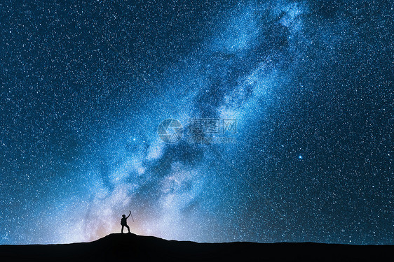 夜晚,带着跋涉杆的人神奇的银河上的剪影太空背景山上人的景观,明亮的银河,天空星星美丽的星系旅行蓝色的星图片