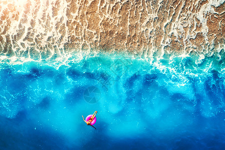 鸟瞰欧洲早晨海上粉红色游泳圈上游泳的女人夏季景观女孩,海滩,碧水,日出时美丽的波浪的风景旅行度假度假胜图片