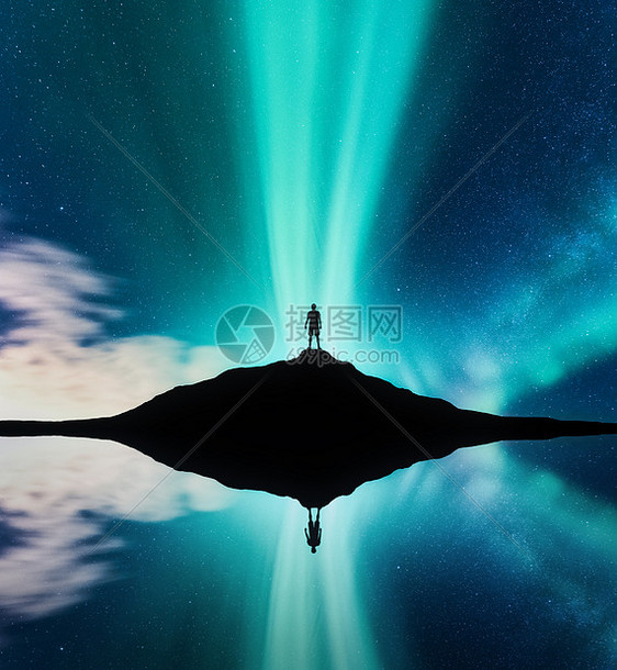 挪威山上站立的人的北极光轮廓北极光人类星星绿色北极光夜间景观与极光,湖泊,天空反射水中旅行山图片