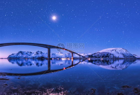 桥紫色的星空,美丽的倒影水中夜风景桥,雪山,天空满月明亮的星星反射海里挪威洛福滕岛的冬天桥紫色的星图片