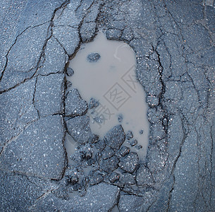 坑洞坑洞图像的破碎裂缝沥青路与脏水坑运输标志的道路维护汽车保险风险的汽车悬架背景图片