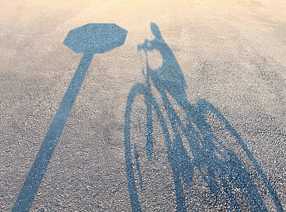 自行车安全意外保险的,孩子的影子自行车上,城市街道道路上的停车标志,儿童安全保护的象征图片