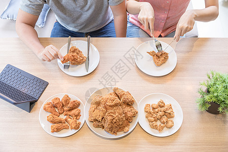 轻的亚洲夫妇吃炸鸡房子的客厅里吃炸鸡,以现代生活方式的为最高观图片