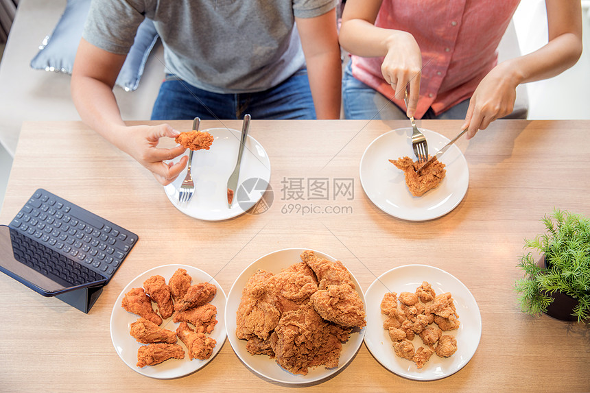 ‘~轻的亚洲夫妇吃炸鸡房子的客厅里吃炸鸡,以现代生活方式的为最高观  ~’ 的图片