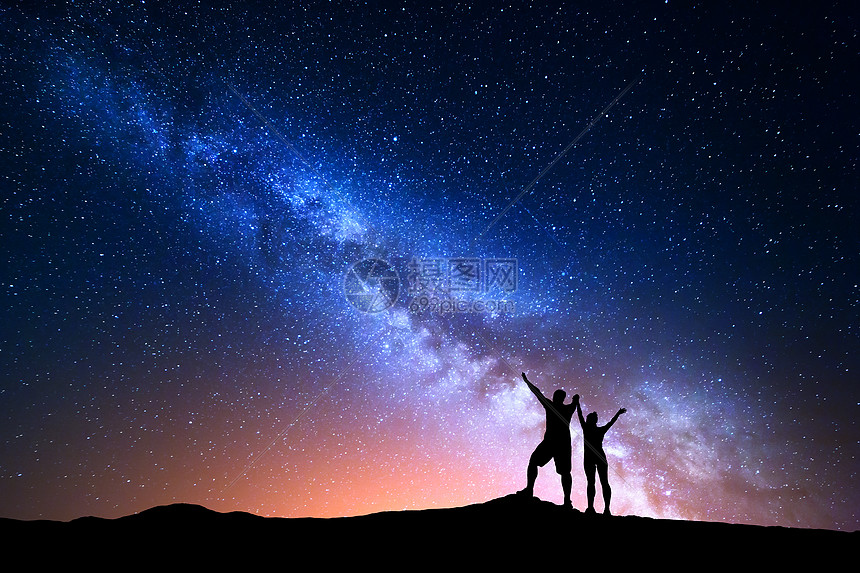 银河系五颜六色的夜空 星星轮廓 站着快乐的男人女人 举手臂山上蓝色的银河山上的人着美丽宇宙的背景高清图片下载 正版图片 摄图网